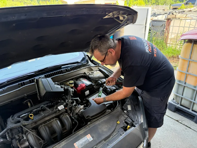 Technician inspecting an open engine bay
